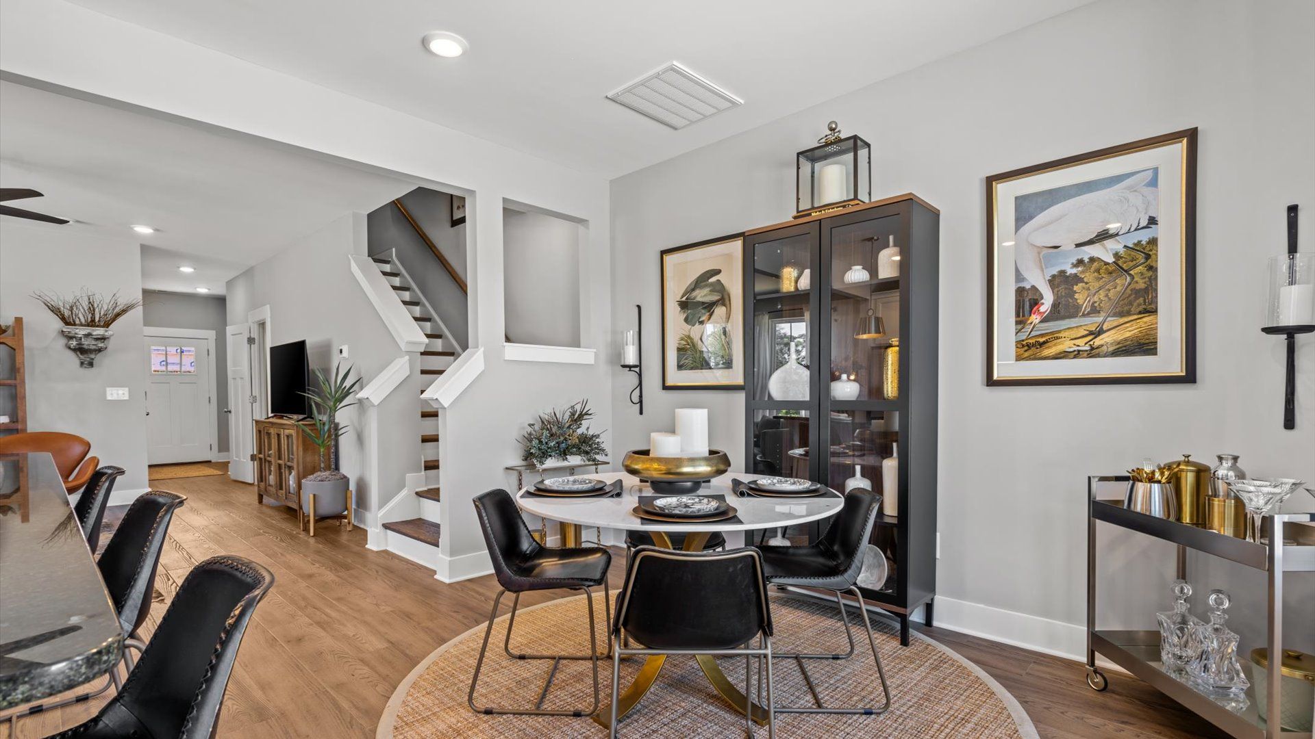 Black and gold, modern breakfast area adjacent from kitchen in two story townhome at Clayton Crossing by DRB Homes
