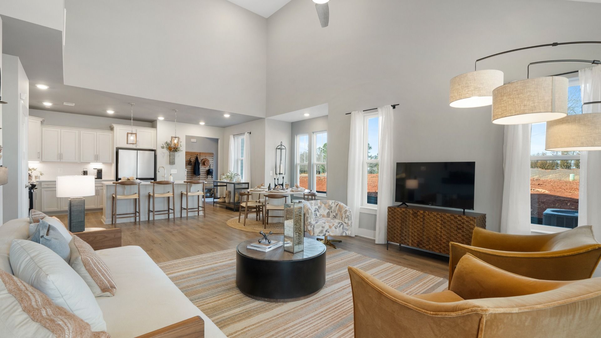 Spacious, open concept living spaces with hardwood flooring and two story ceilings at Barton Hollow by DRB Homes