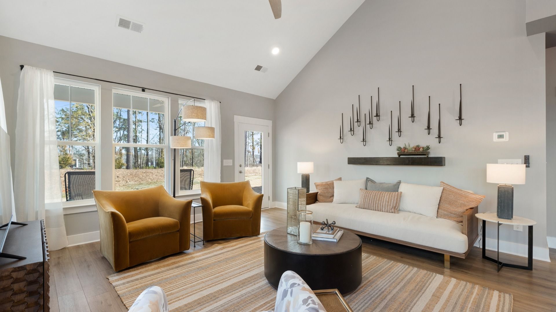 Two story vaulted ceiling family room with large windows and outdoor access at Barton Hollow by DRB Homes in Fountain Inn, SC