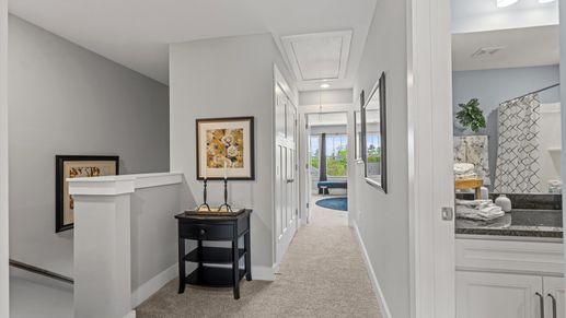 Carpeted hallway with elevated ceilings in two story townhome at Clayton Crossing by DRB Homes in Arden, NC