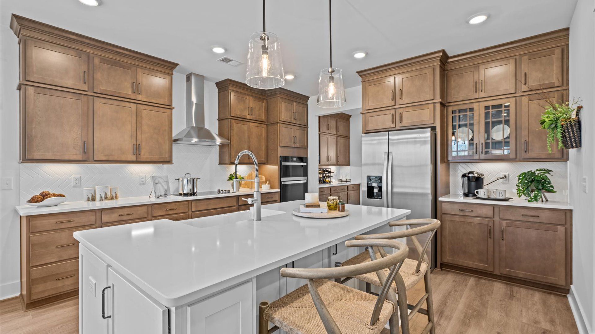 Two story home in Woodruff, SC with spacious kitchen with wooden cabinetry and large island at Pinebrook by DRB Homes