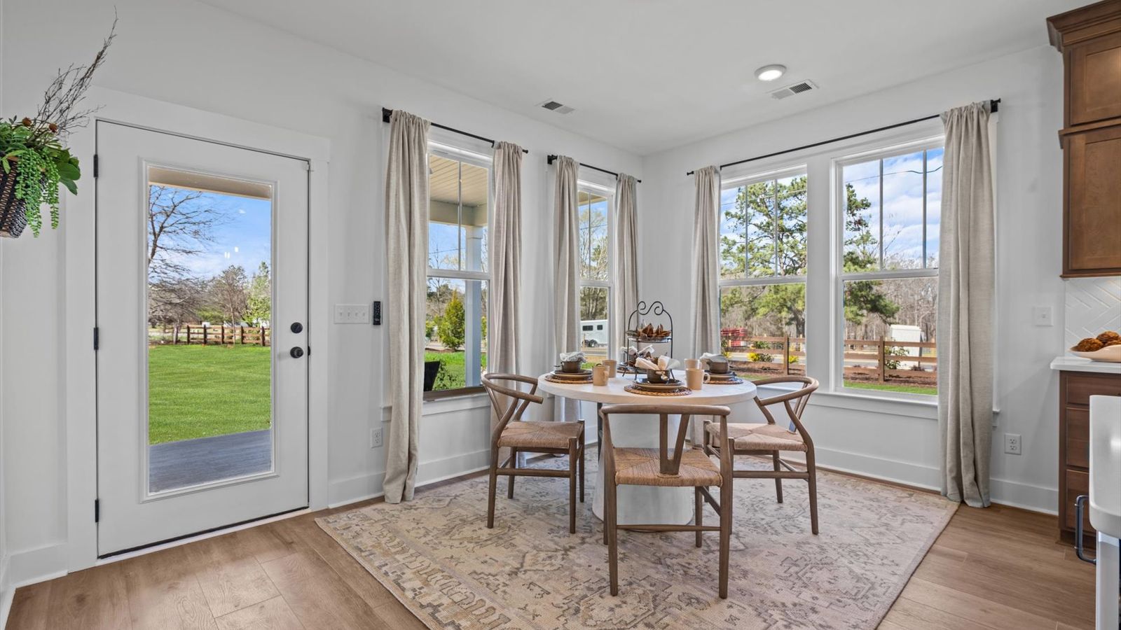 Modern breakfast area adjacent from wooden cabinetry kitchen at Pinebrook by DRB Homes in Woodruff, SC