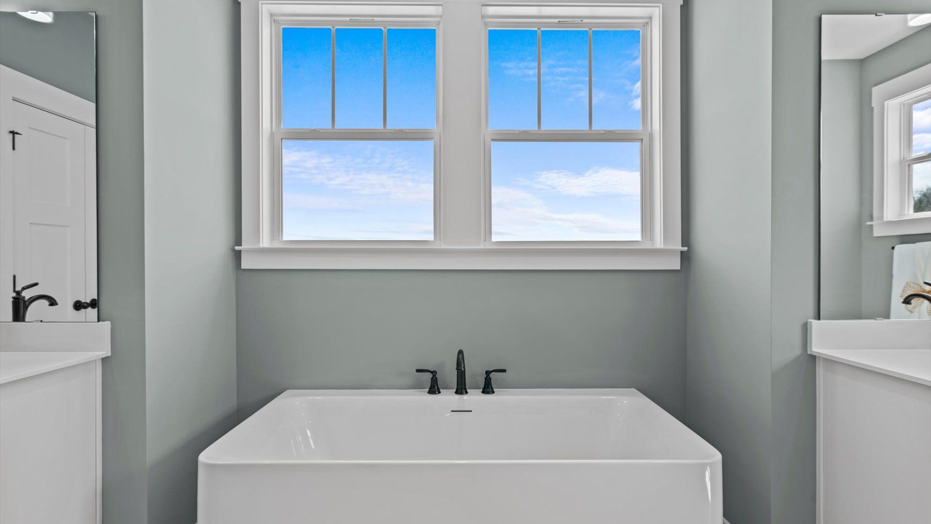 Primary bathroom with spa like bath tub and separate vanities at Pinebrook by DRB Homes in Woodruff, SC