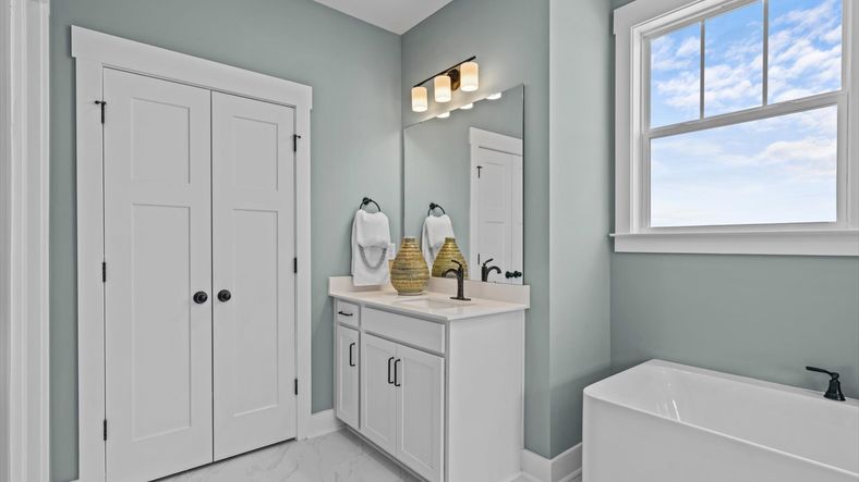 Primary Bathroom with large bath tub and separate vanities at Pinebrook by DRB Homes in Woodruff, SC