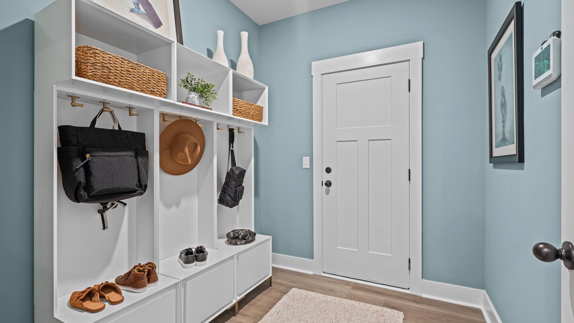 Garage entry mudroom with hardwood flooring at Pinebrook by DRB Homes in Woodruff, SC
