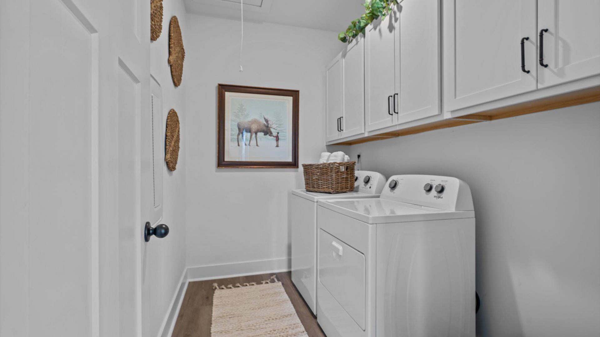 Hardwood flooring laundry room with upper cabinetry at Pinebrook by DRB Homes in Woodruff, SC
