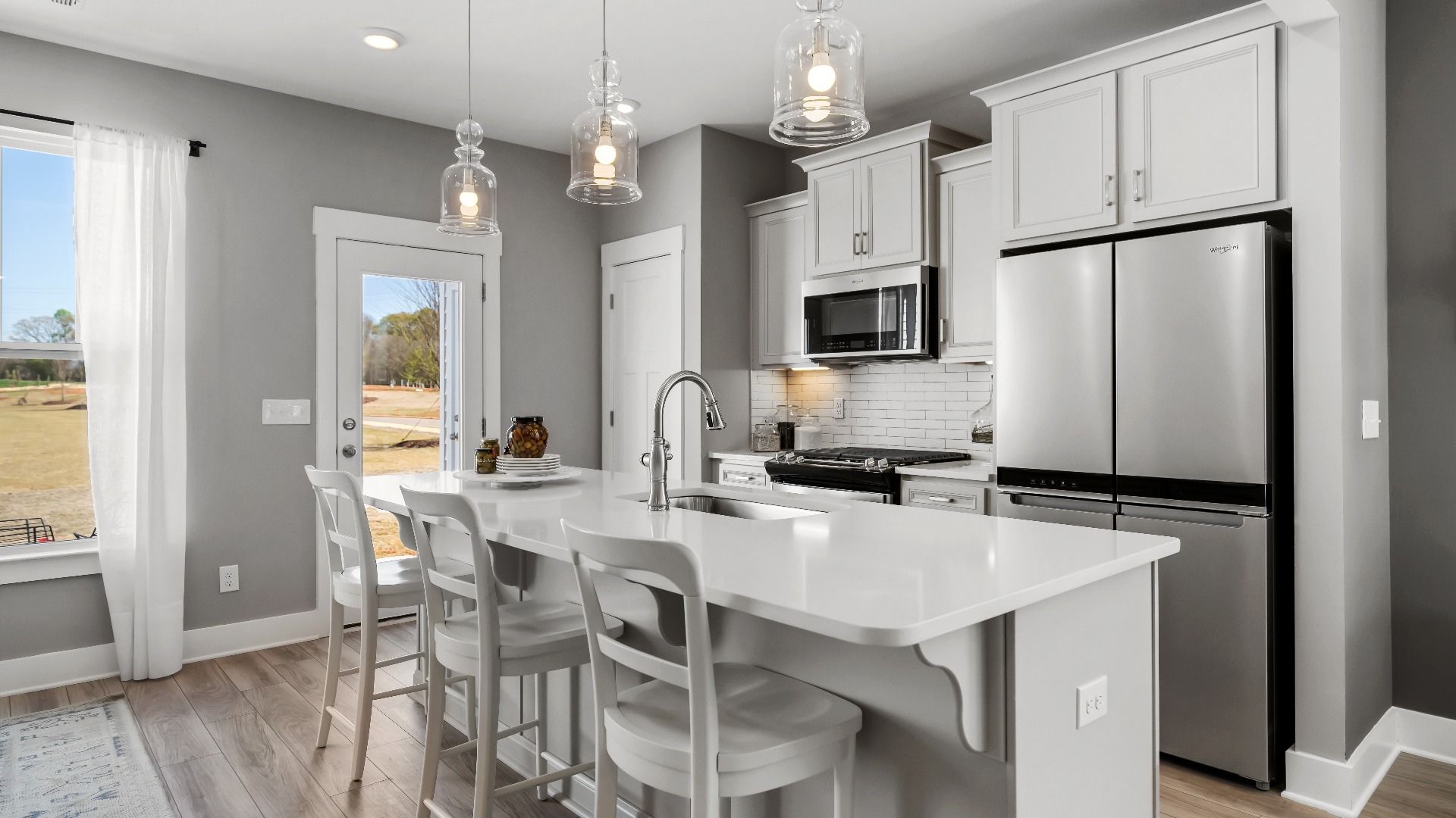 Kitchen with large island with white quartz countertops in two story townhome at Saluda Crossing by DRB Homes in Piedmont, SC