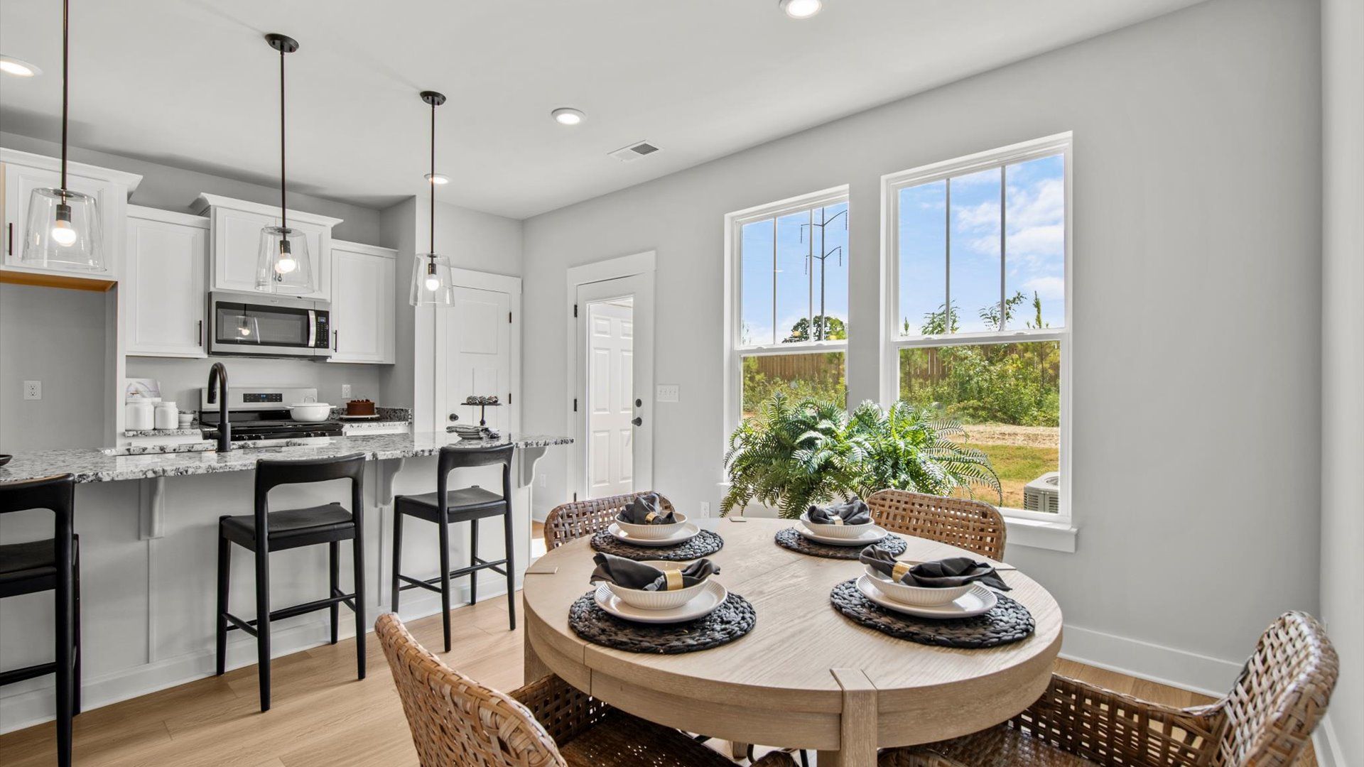 Modern farmhouse breakfast area with large windows in two story townhome at Saluda Crossing by DRB Homes in Piedmont, SC