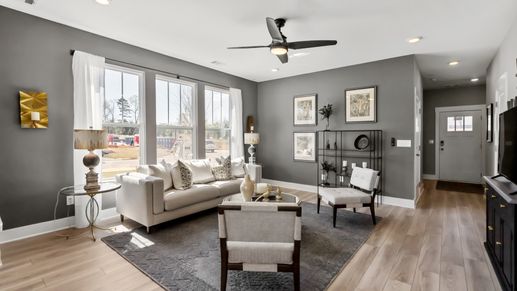 Spacious, cozy, modern family room with hardwood floors and large windows at Saluda Crossing by DRB Homes in Piedmont, SC
