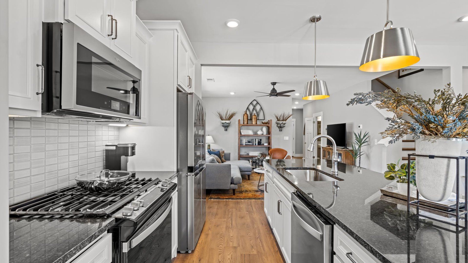 Granite countertop kitchen with modern pendant lighting in two story townhome at Saluda Crossing by DRB Homes in Piedmont, SC