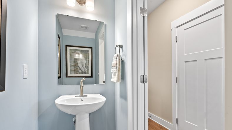 Blue accented half bathroom in two story townhome at Saluda Crossing by DRB Homes in Piedmont, SC