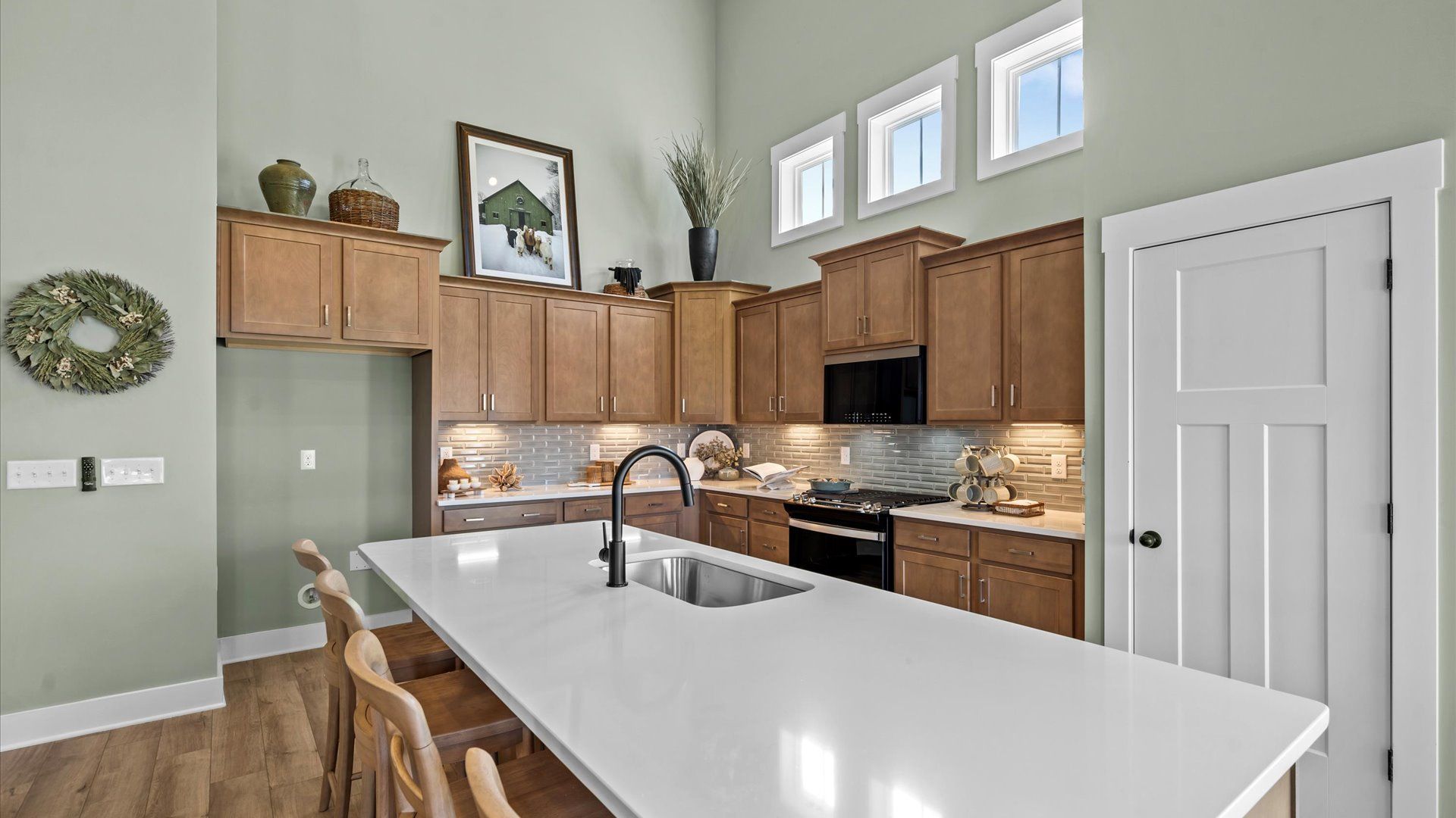 Inviting kitchen with two story ceilings and wooden cabinetry at Mulberry Estates by DRB Homes in Simpsonville, SC