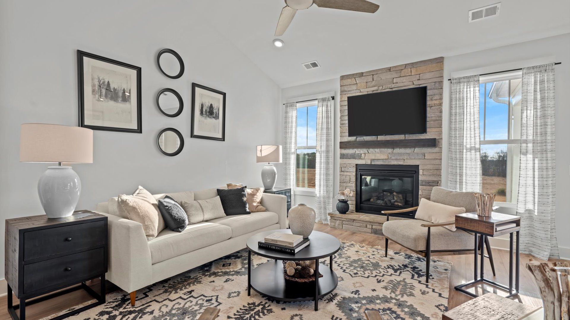 Family room with hardwood flooring and stone fireplace in two story home at Mulberry Estates by DRB Homes in Simpsonville, SC