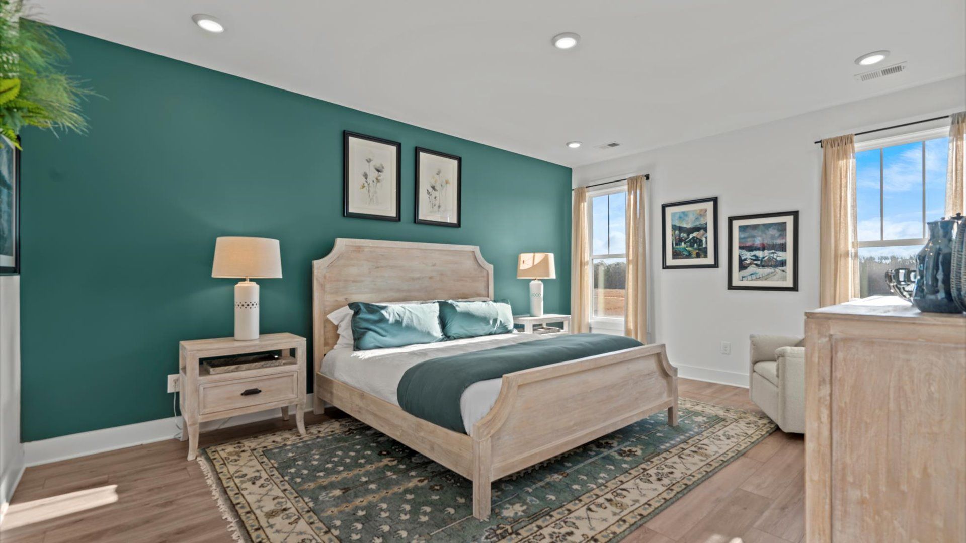 Serene primary suite with hardwood flooring and large windows in two story home at Mulberry Estates by DRB Homes