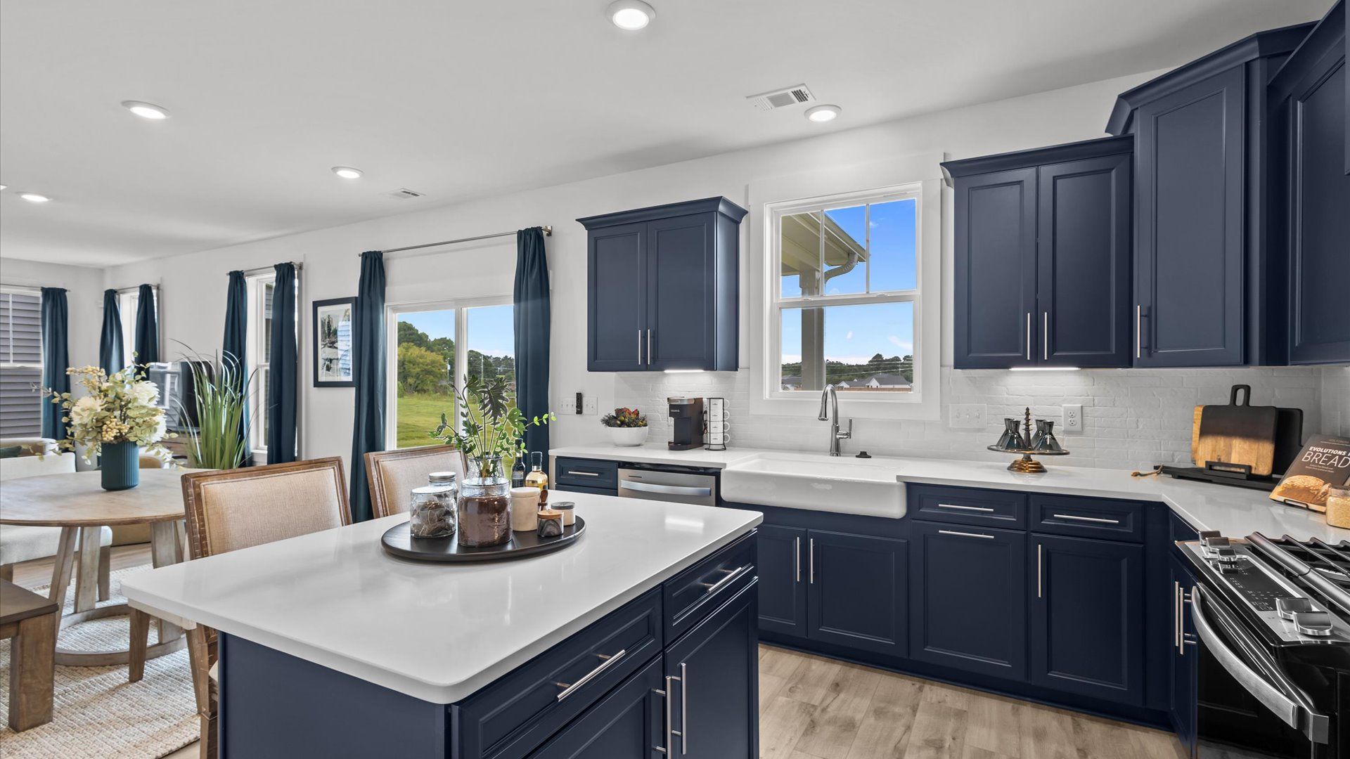 Gorgeous navy blue kitchen with white quartz countertops and island in two story home at DRB Homes in Easley, SC