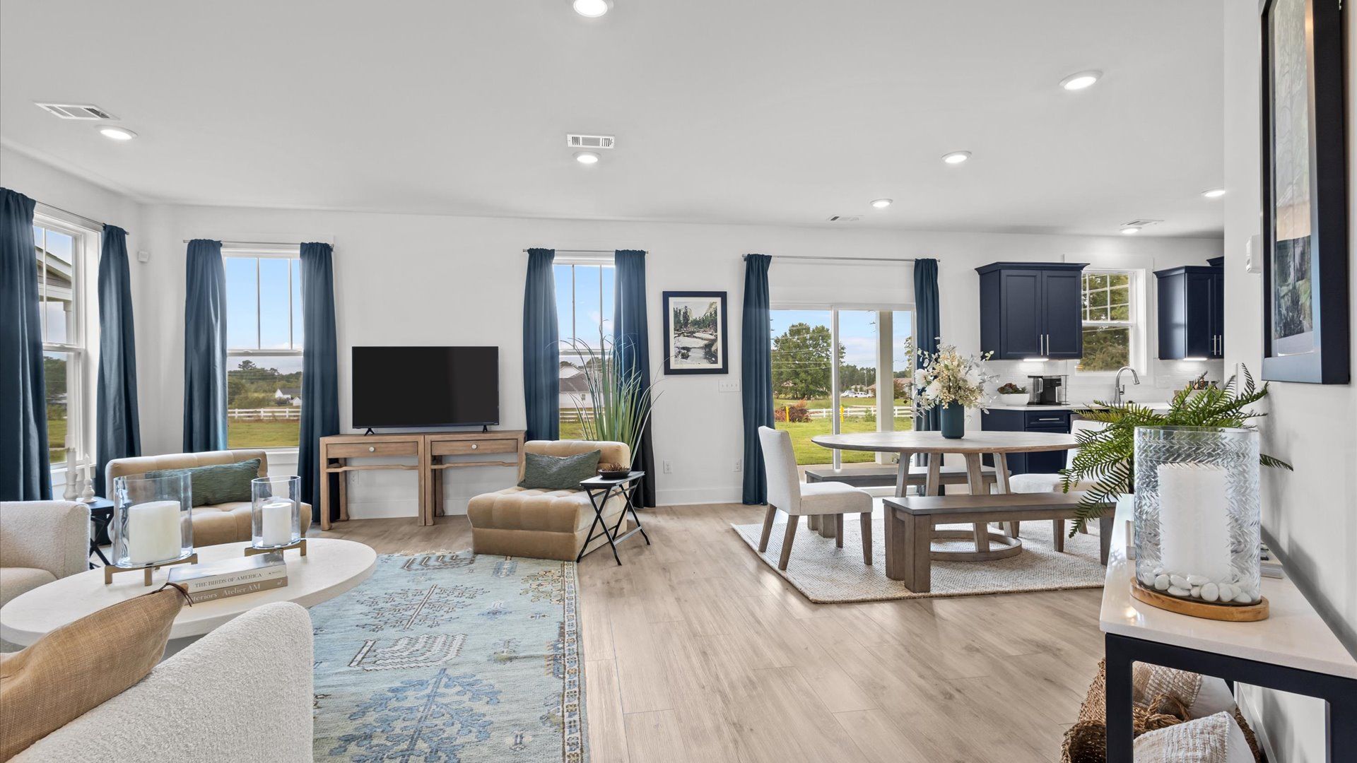 Cozy, open concept family room with large windows & gorgeous hardwood flooring in two story home at DRB Homes in Easley, SC