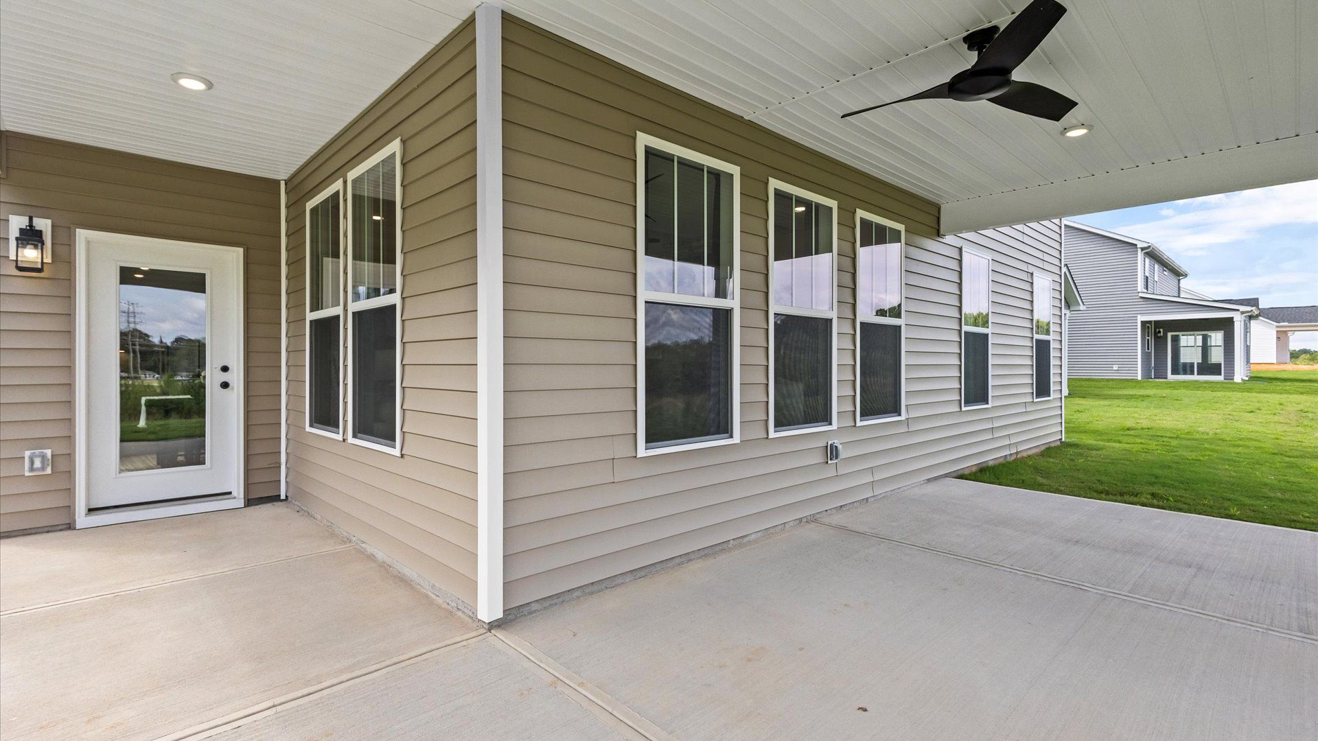 Spacious covered rear porch with ceiling fan overlooking private backyard in two story home at DRB Homes in Easley, SC
