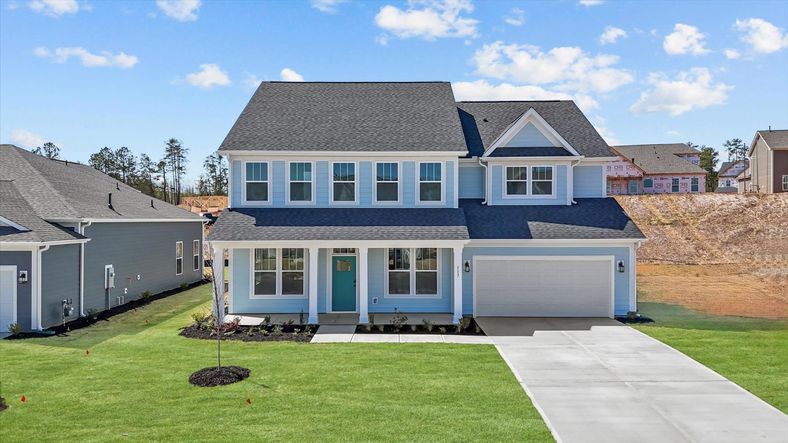 Bright blue home with plentiful windows and long driveway in Woodruff, SC at Pinebrook by DRB Homes