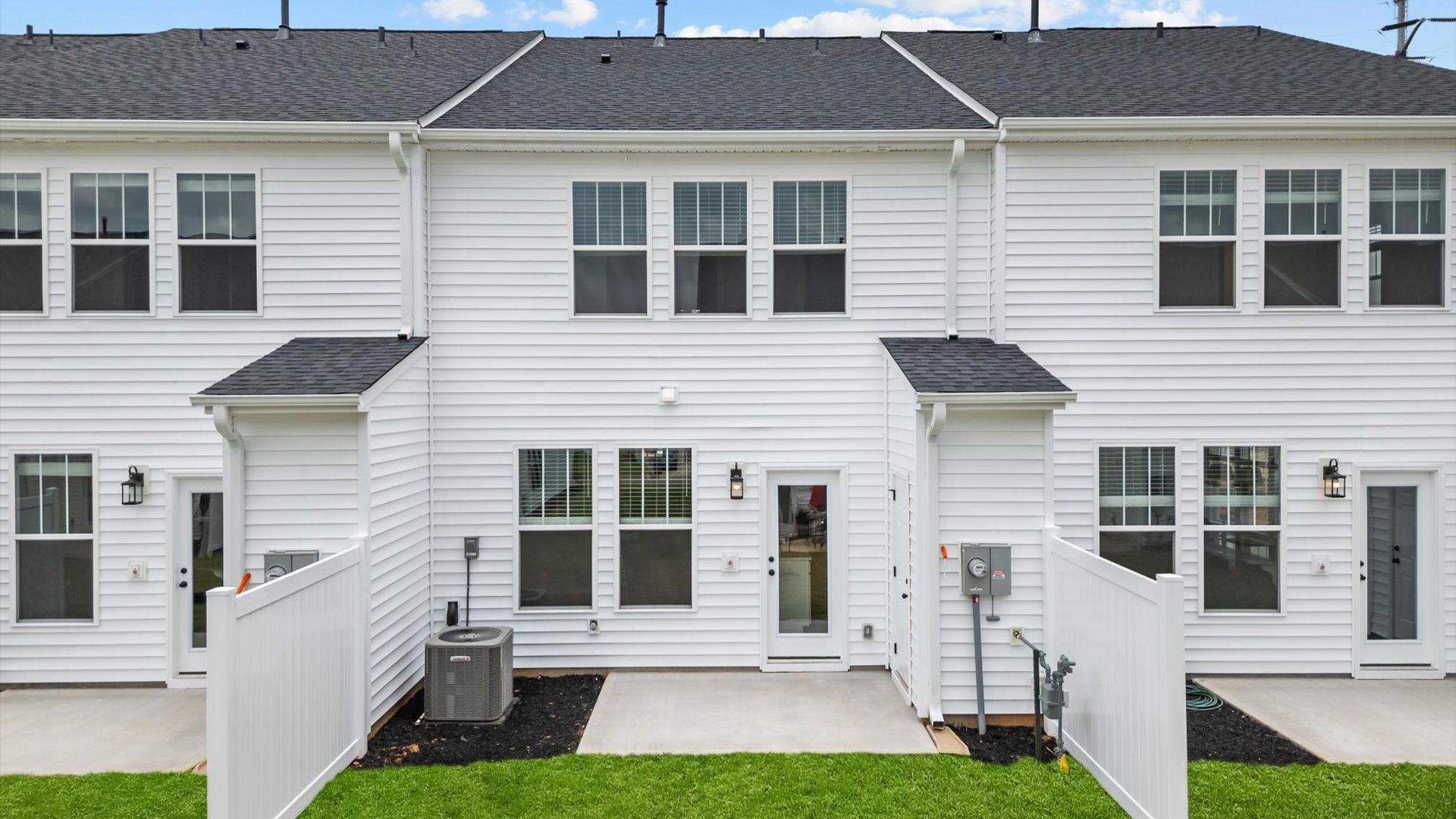 Back of two story white exterior townhome at Hickory Heights by DRB Homes near Downtown Greenville, SC