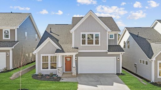 Finley floorplan with neutral exterior and stone columns at The Reserve at Livingston Park by DRB Homes in Easley, SC