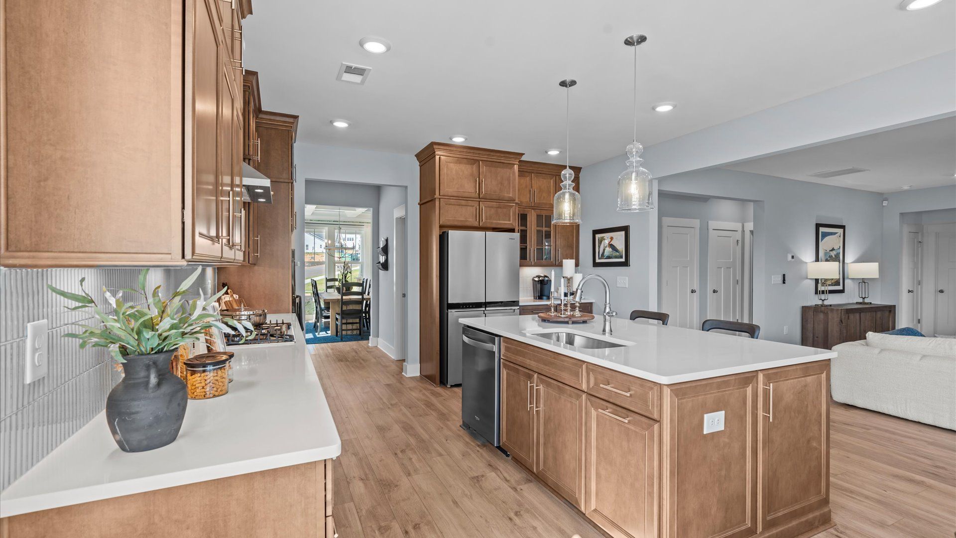 Exceptional kitchen featuring a spacious island, eye-catching pendant lights, and modern finishes at Wells Crossing