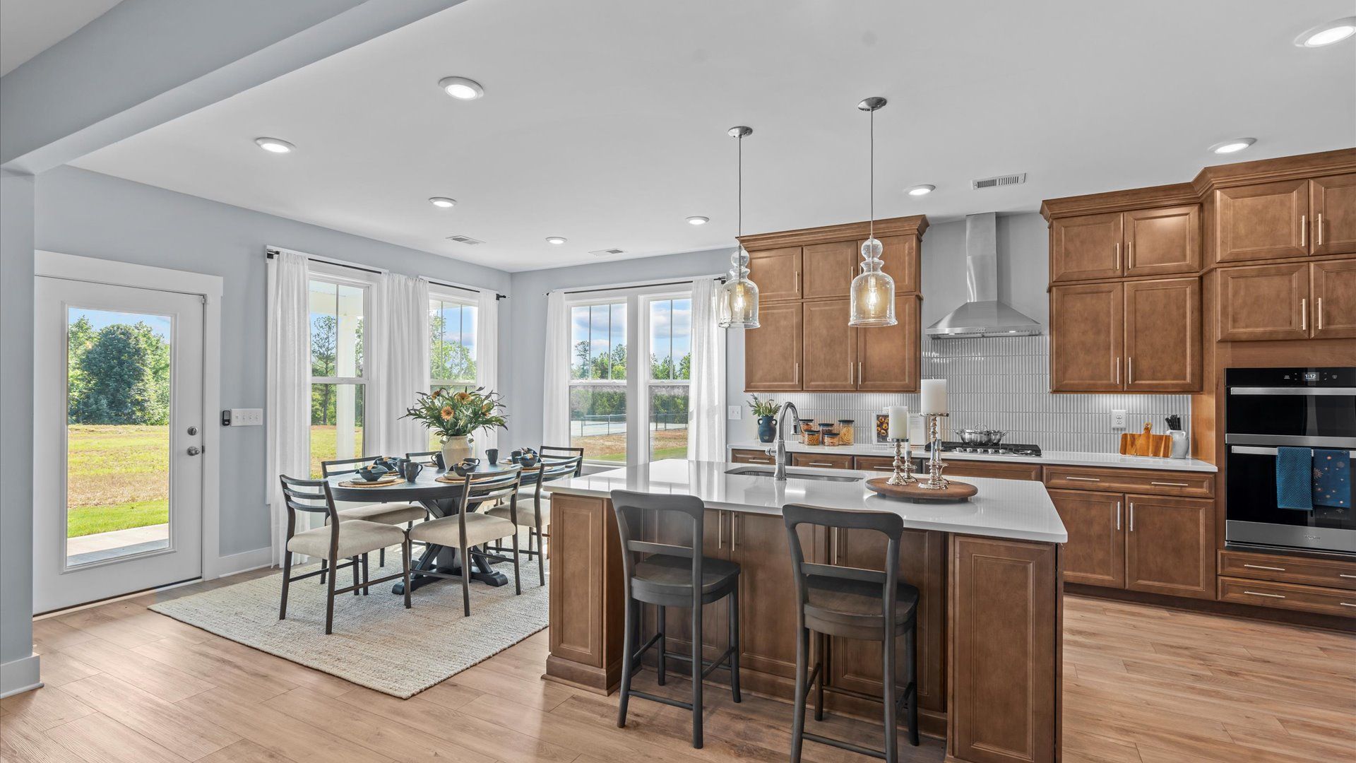 Elegant kitchen with large island and pendant lighting in this first-class DRB Homes design