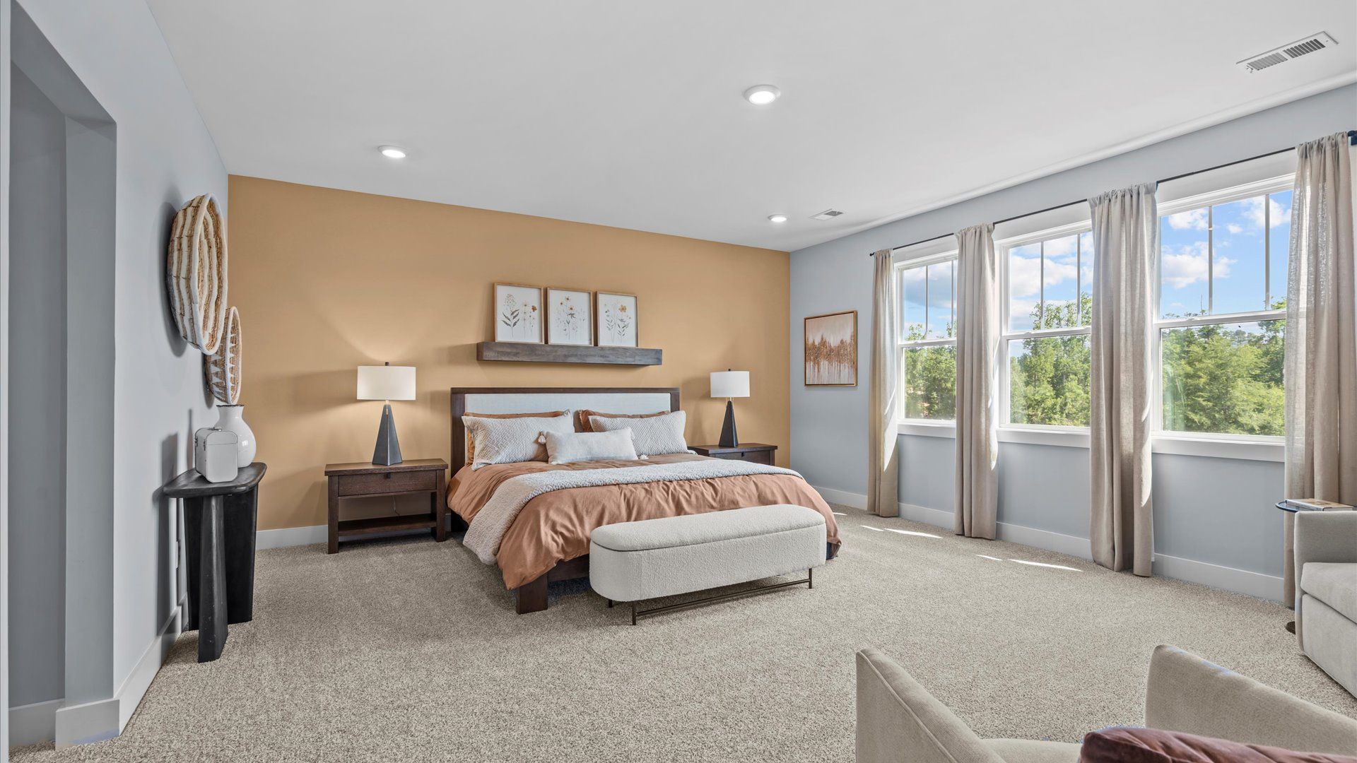 Serene and stylish primary bedroom featuring carpet flooring and a thoughtful, modern layout at Wells Crossing
