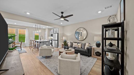 Spacious family room with ceiling fan, and hardwood flooring at Aspen Ridge by DRB Homes in Lyman, SC