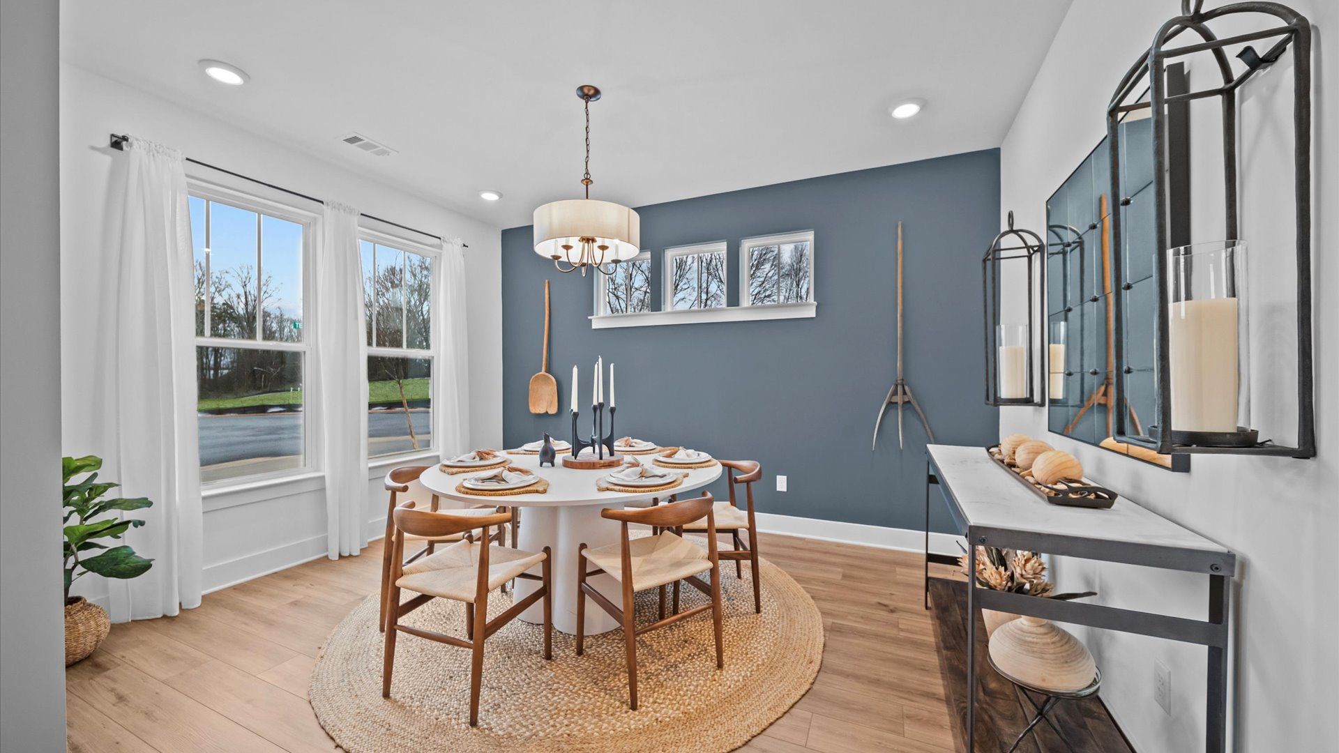 Inviting, spacious dining room with large windows, hardwood flooring, chandelier, and elevated ceilings