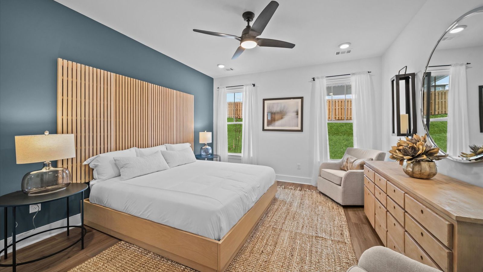 Primary suite with hardwood flooring, large windows, and ceiling fan at Aspen Ridge by DRB Homes in Lyman, SC