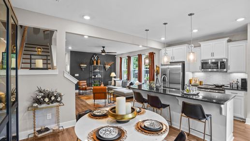 Black and white modern kitchen with granite countertops and tiled backsplash at Clayton Crossing by DRB Homes in Arden, NC