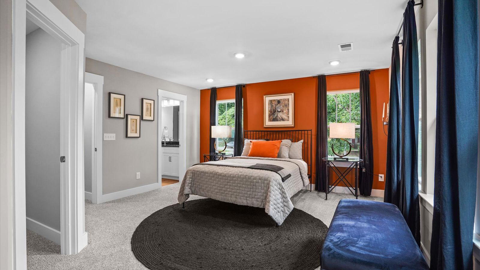 Cozy, inviting primary suite adorned with windows and plush carpet in two story townhome at Clayton Crossing by DRB Homes