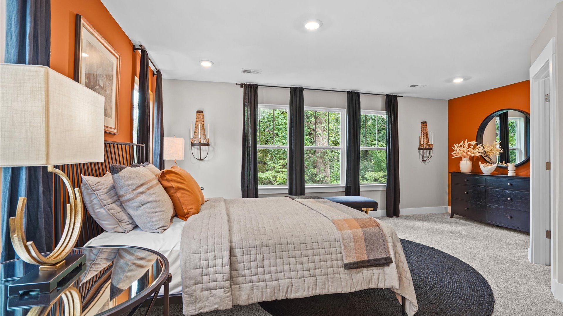 Cozy primary suite with large windows and plush carpets at Clayton Crossing by DRB Homes in Arden, NC