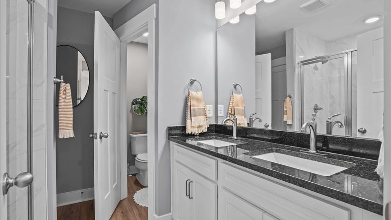Primary bathroom with double sink vanity with granite countertops at Clayton Crossing by DRB Homes in Arden, NC