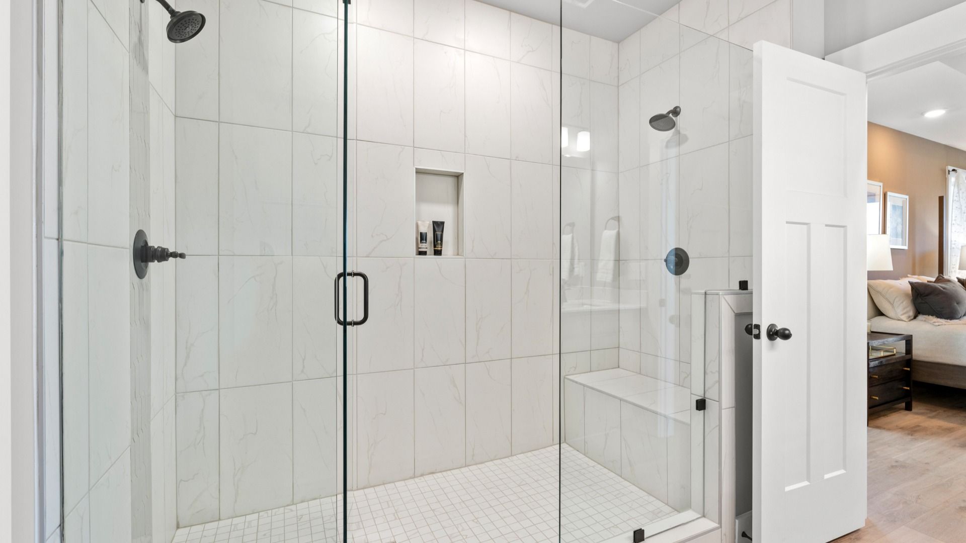 Memorable mornings begin in this elegant primary bathroom with tiled walk-in Roman shower