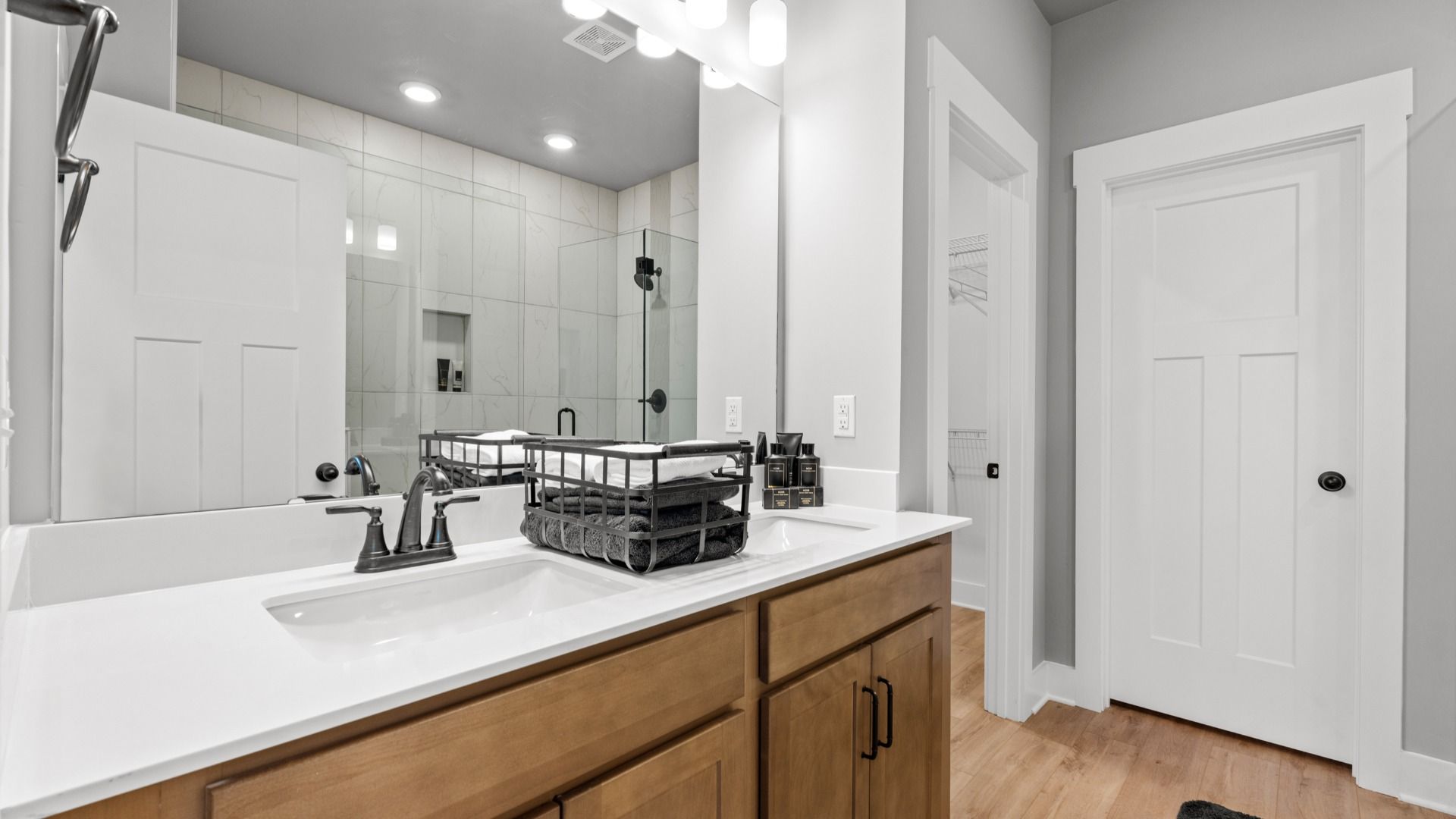 Superior en-suite primary bathroom with stylish dual vanity and tiled walk-in shower crafted with high standards in mind