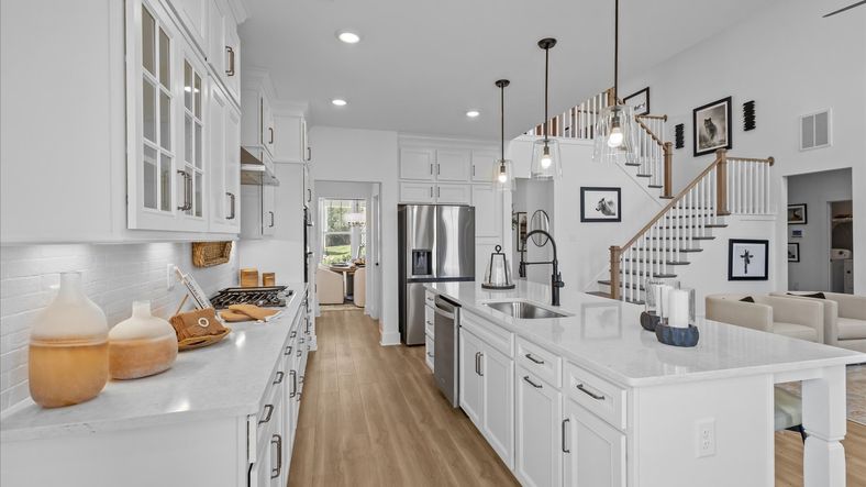 Accomplished kitchen design featuring pendant lighting above a statement island for both prep and gathering