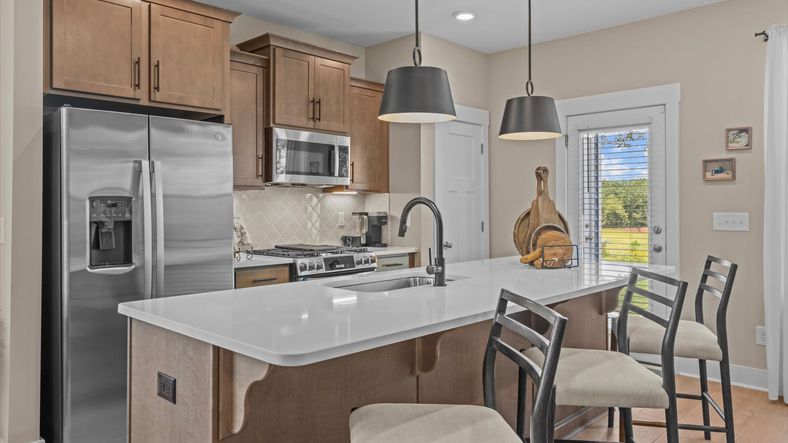 Modern kitchen with 9-foot island and pendant lighting in 2 story townhome at Ransdell Pointe by DRB Homes in Spartanburg, SC