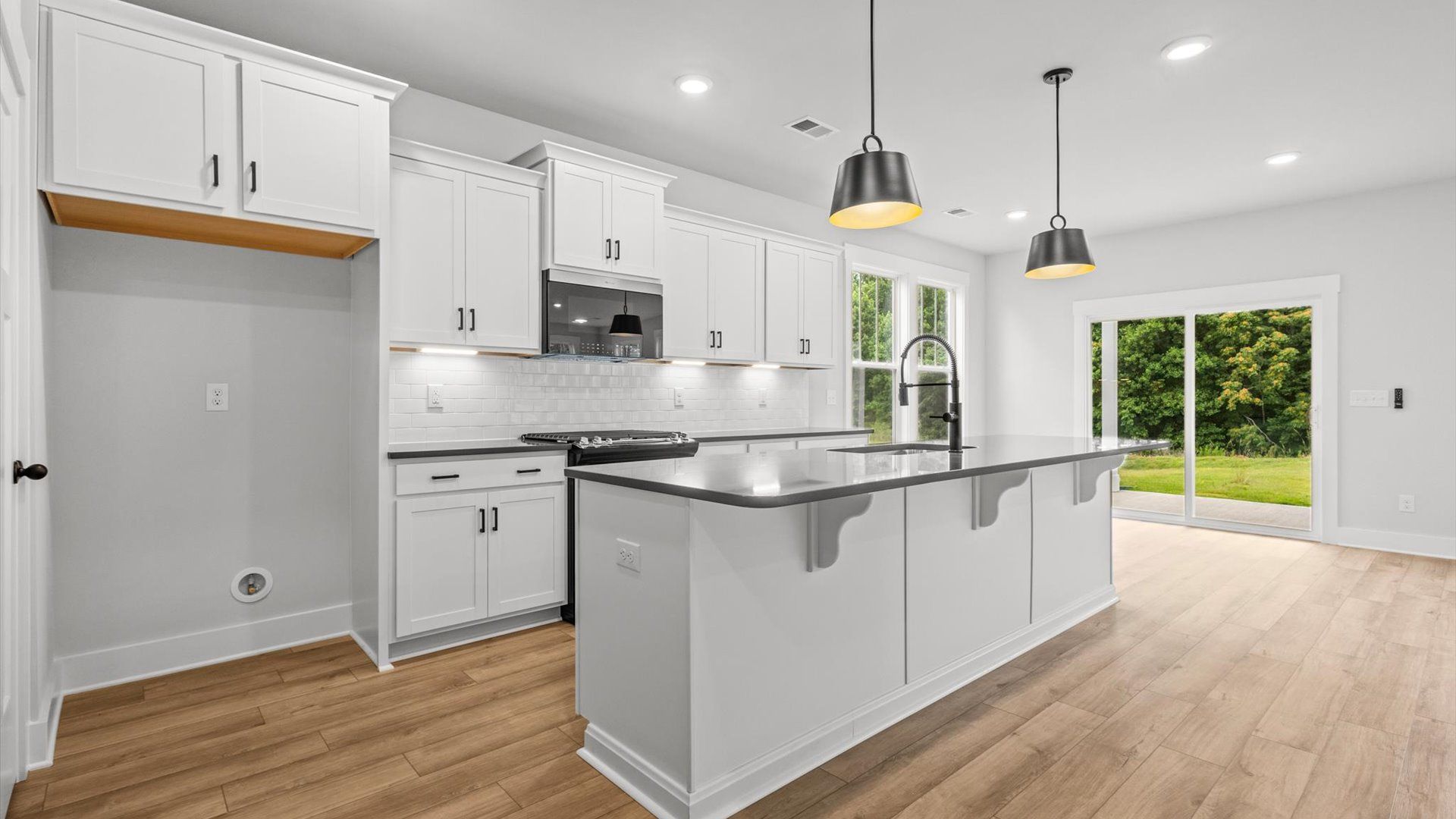 Neroli home plan open concept kitchen with large island and tile backsplash overlooking family and breakfast areas