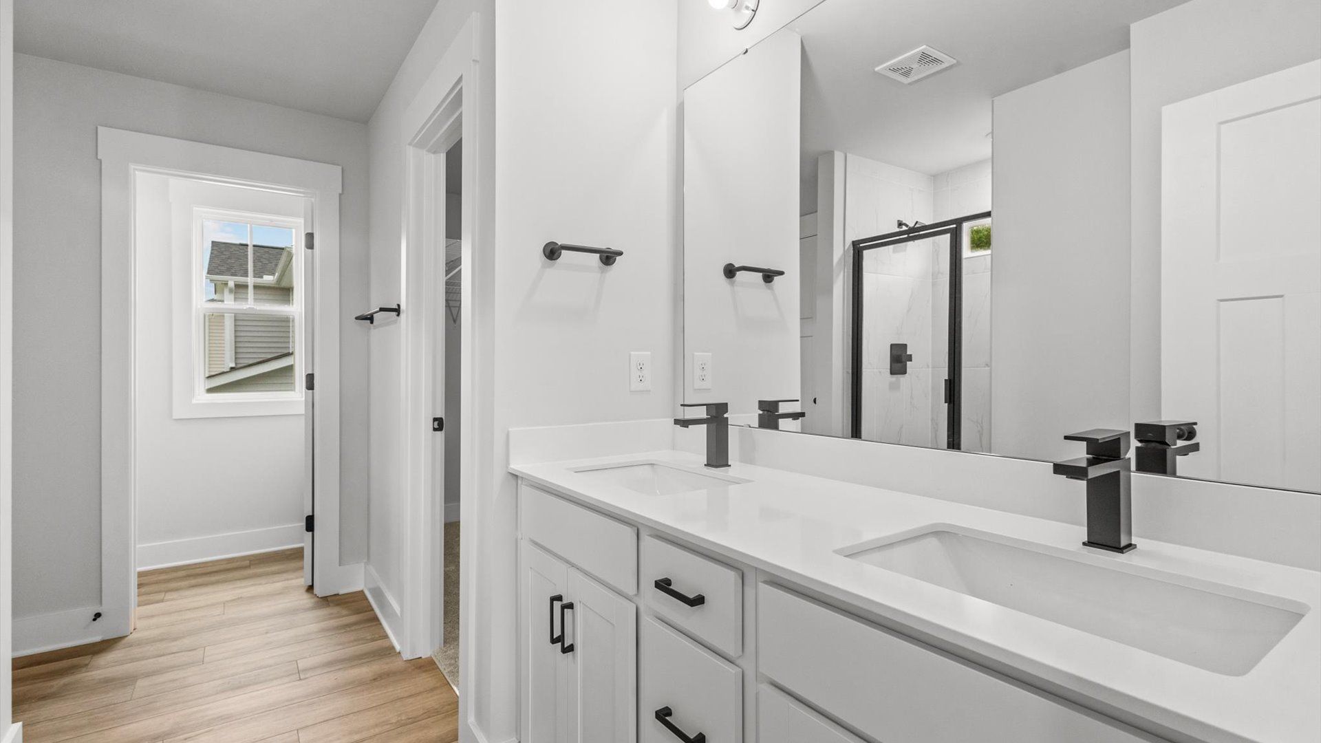 Neroli home plan primary bath with dual vanities, tile shower, toilet room and linen closet