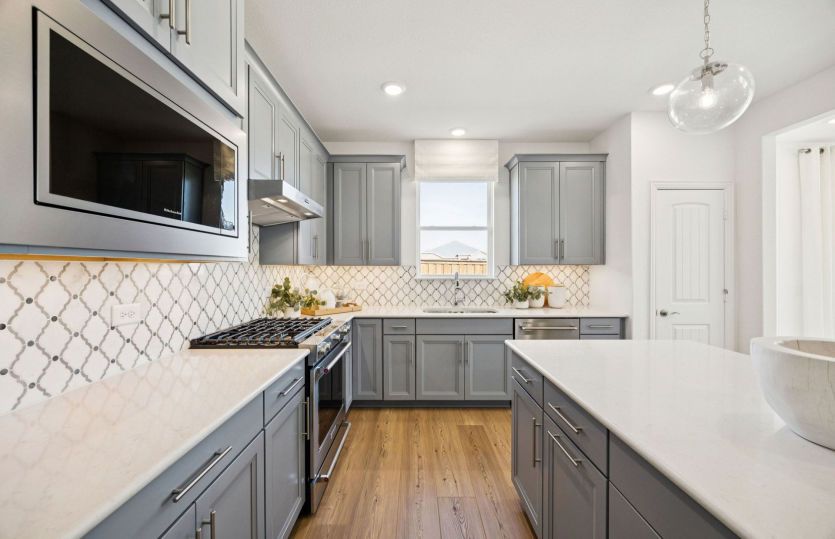 Spacious kitchen with pendant and recessed lighting