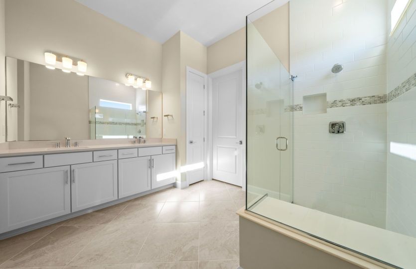 Owner's bathroom with dual-sink vanity and glass shower