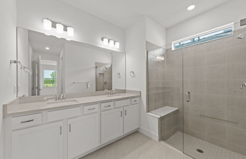 Owner's bathroom with dual-sink vanity and glass shower