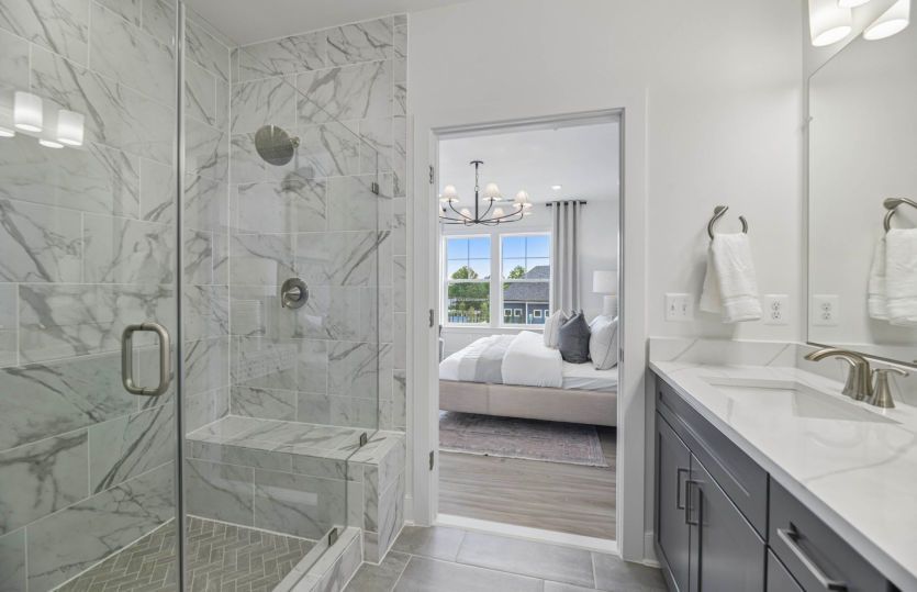 Frameless Glass Shower with Seat and Dual Shower Heads in the Owner's Suite