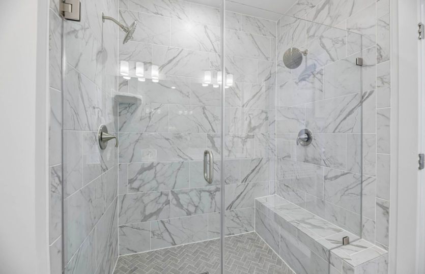 Frameless Glass Shower with Seat and Dual Shower Heads in the Owner's Suite
