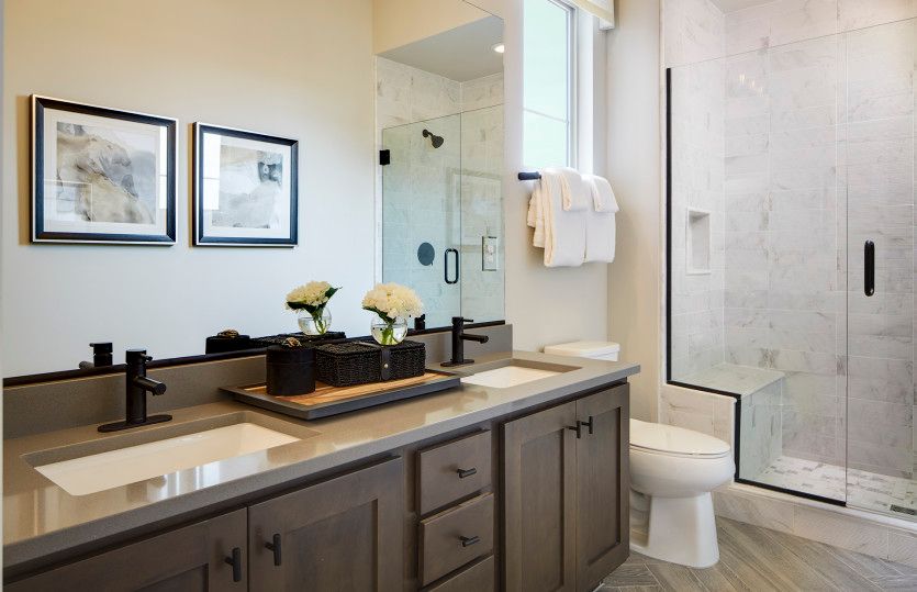 Secondary bathroom with dual sinks and walk-in shower