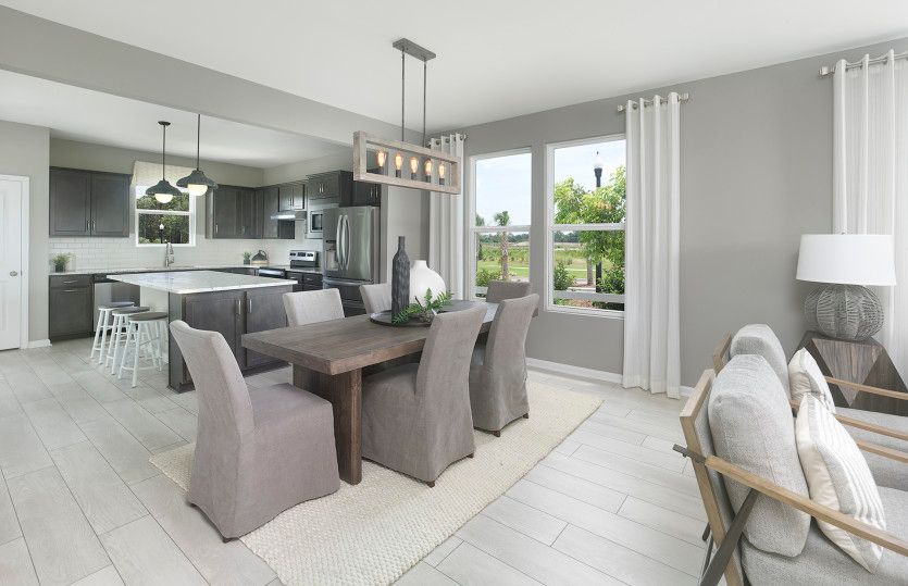 Charming dining room flows from the kitchen space, ideal for enjoying a delicious meal. Model Repres