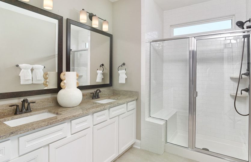 Luxurious Owner's Bathroom with dual vanity and tile shower. Model Representation.