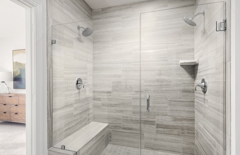 Frameless Shower with a Bench and Ceramic Tile in the Owner's Bathroom
