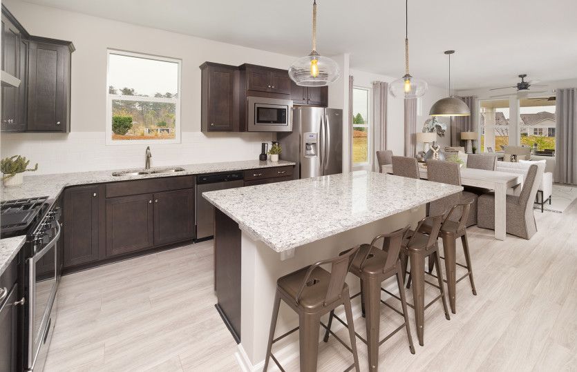 Spacious kitchen area with a window above the sink, beautiful countertops, and a large island.